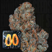 Nahaufnahme von Riviera Drip von Nine Weeks Harvest mit orangefarbenen Haaren und geschnittener Papaya im Vordergrund.