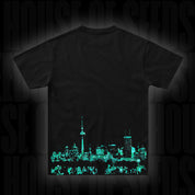 Das Doja T-Shirt Berlin Green von Doja zeigt eine leuchtend blaugrüne Stadtsilhouette auf dem unteren Rücken.